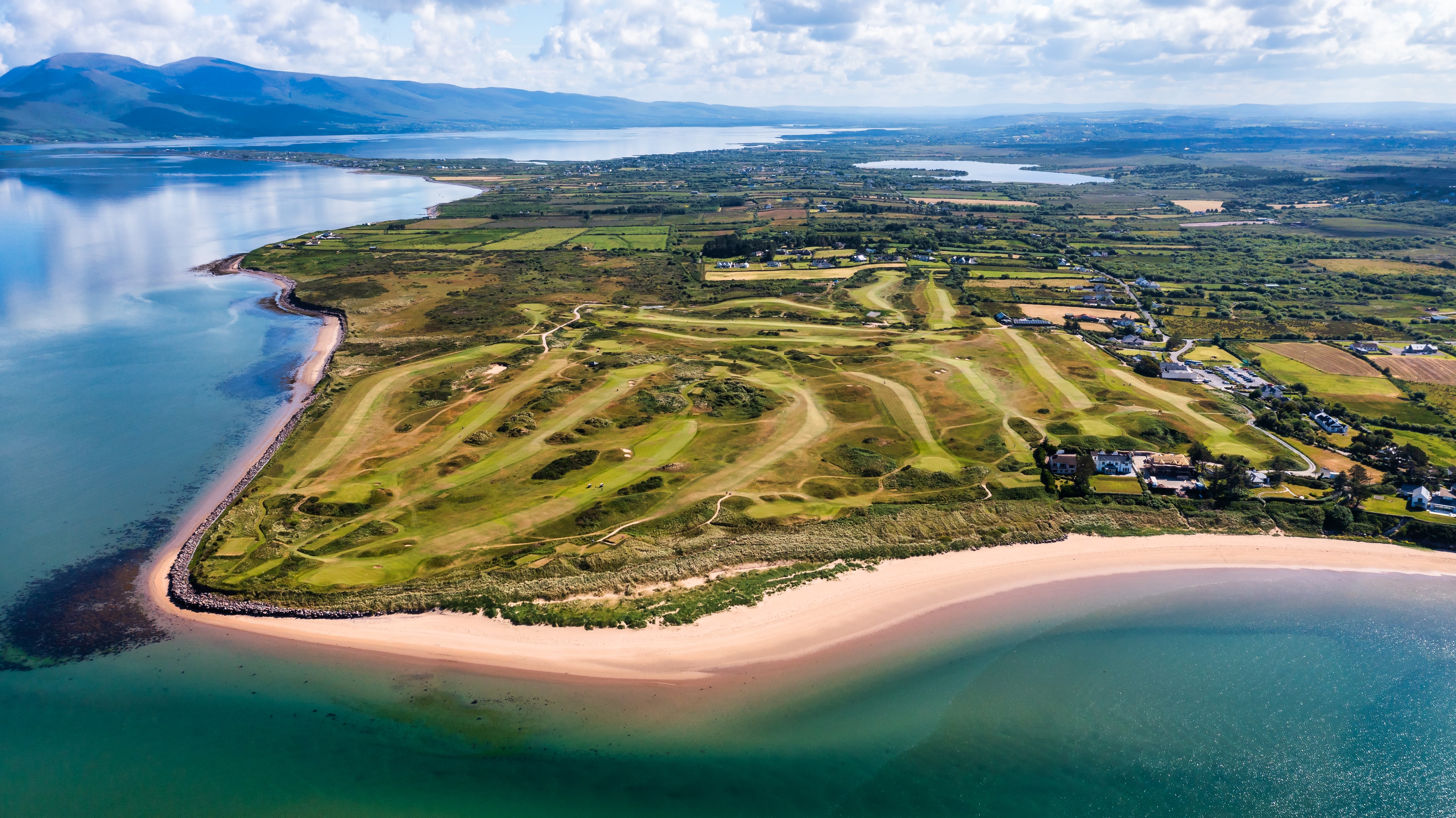 Aerial view of the Dooks peninsula with golden sand beach wrapping the course