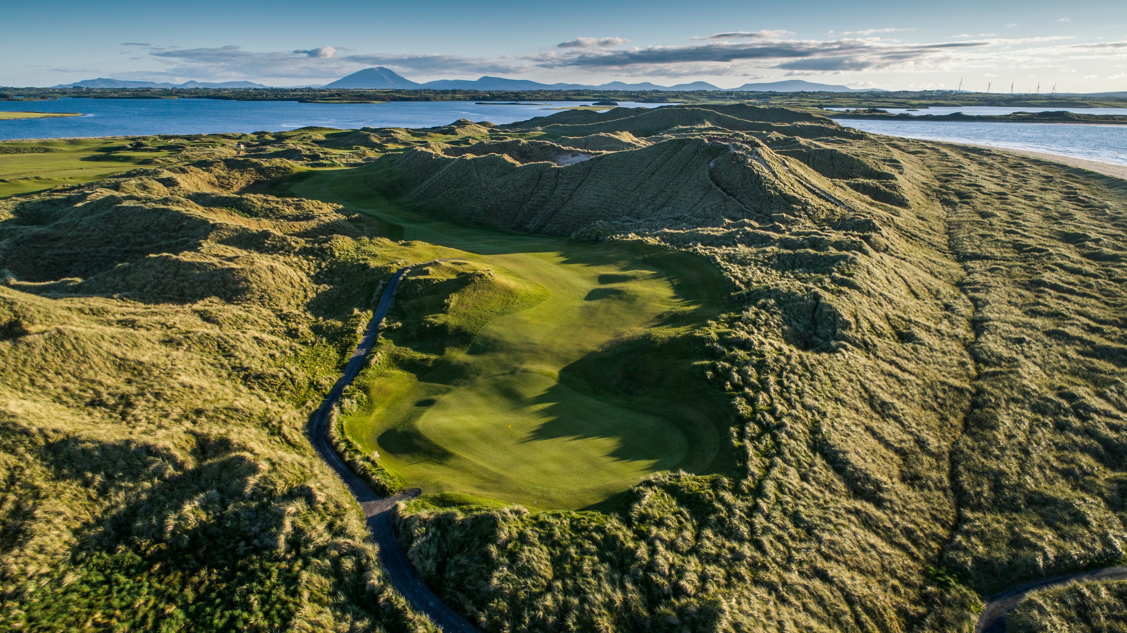 Aerial view of Enniscrone Golf Club fairways winding through towering sandhills