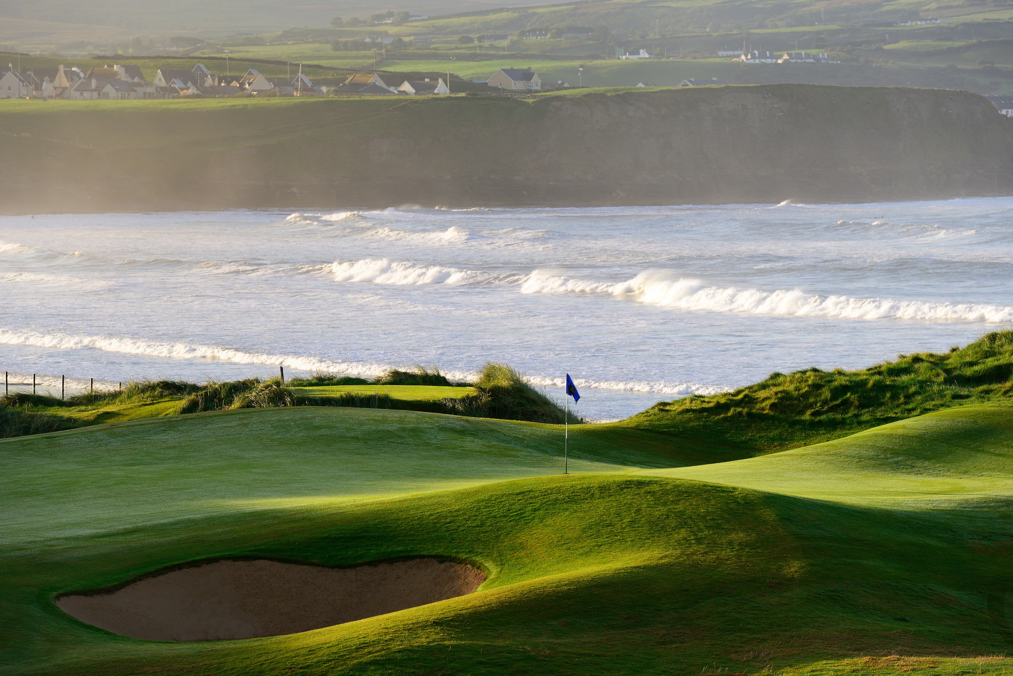 6th hole at Lahinch Golf Club with the ocean and village of Lahinch beyond